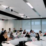 A group of diverse students studying together in a modern university library, highlighting the collaborative learning environment.