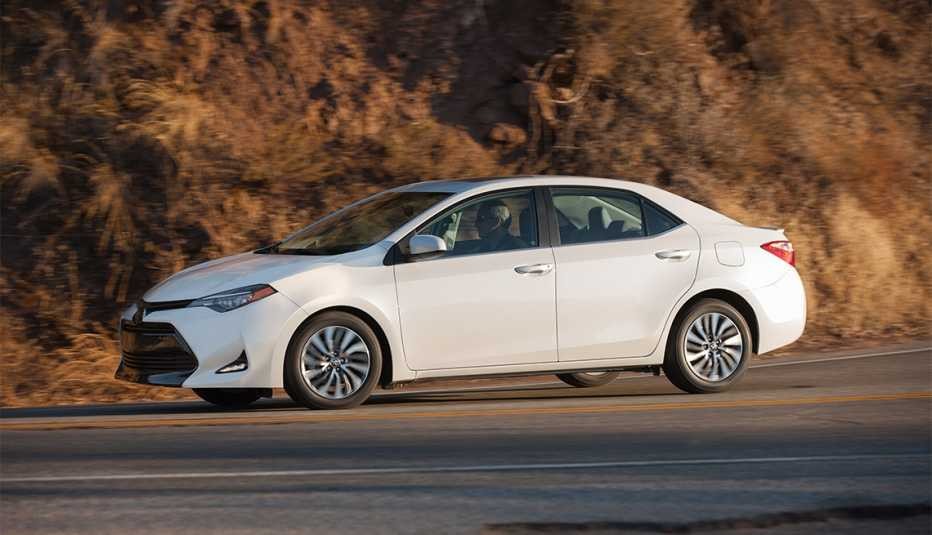 White 2017 Toyota Corolla parked on a paved road, showcasing its compact and modern design