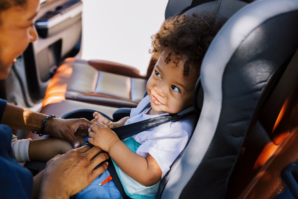 A parent securing a child in a car seat