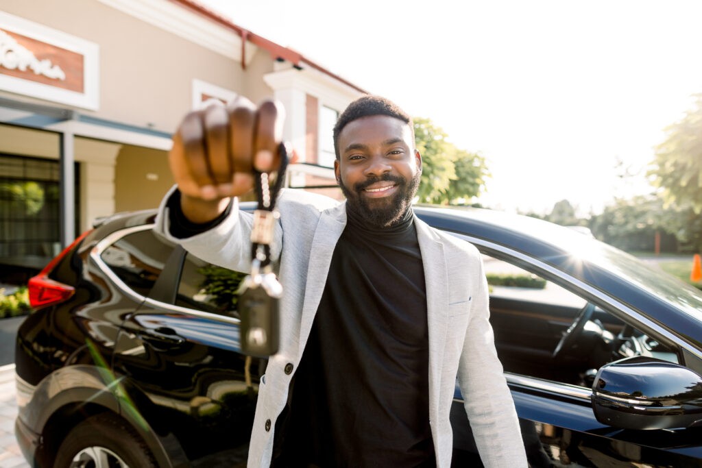 Happy car owner with keys thanks to car loan programs like KEYS, supporting employment.