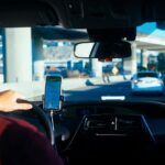 A person uses a smartphone for car navigation while driving a Zipcar.