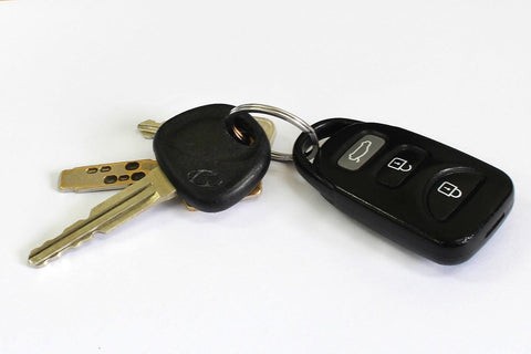 A car key and a separate remote fob lying side by side