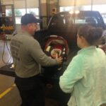 MCFRS Technician Assisting with Infant Car Seat Installation