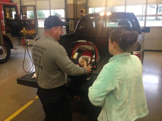 MCFRS Technician Assisting with Infant Car Seat Installation