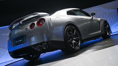 Low angle view of a silver Nissan sports car showcased at an automotive event