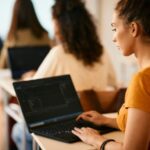 Female student learning coding on laptop, representing structured learning and career change