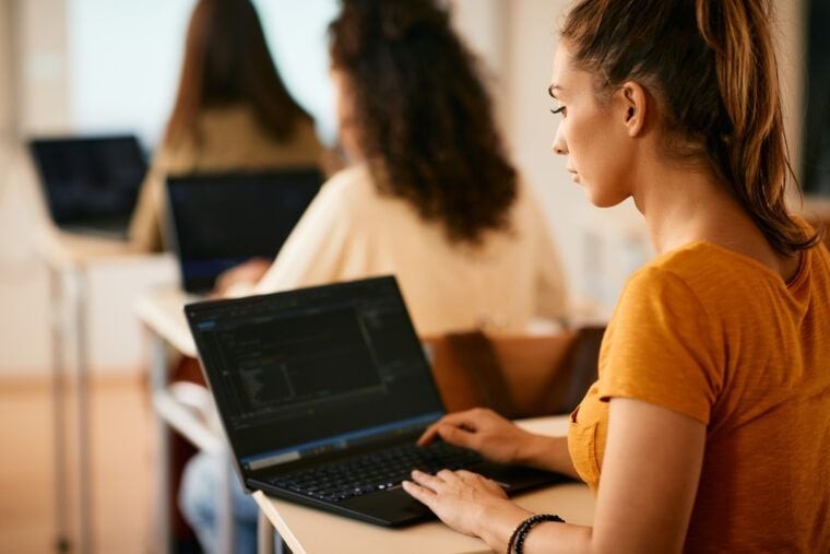 Female student learning coding on laptop, representing structured learning and career change