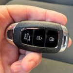 Close-up of a person's hand programming a car key fob