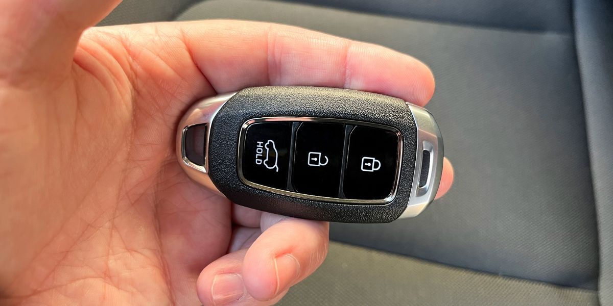 Close-up of a person's hand programming a car key fob