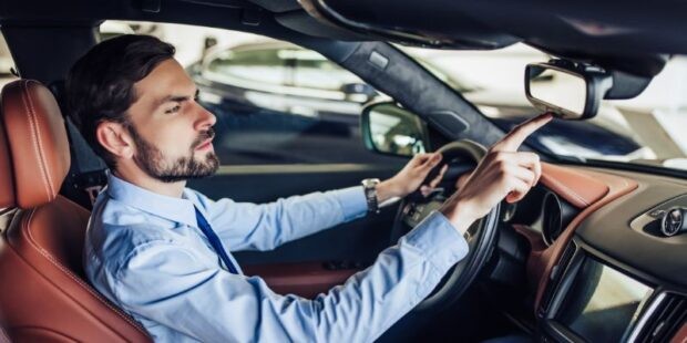 Man programming car mirror buttons to open garage door, emphasizing ease of access for industrial and residential settings.