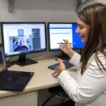 Dr. Kamia Thakur virtually visits with patient Mildred Shelly, gesturing and smiling on a video screen.