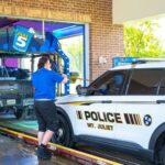 Police car entering Take 5 Car Wash for fleet program service