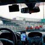 A DoorDash driver using a navigation app while driving a rented car for deliveries, highlighting the flexibility and convenience of car rentals for gig economy jobs.