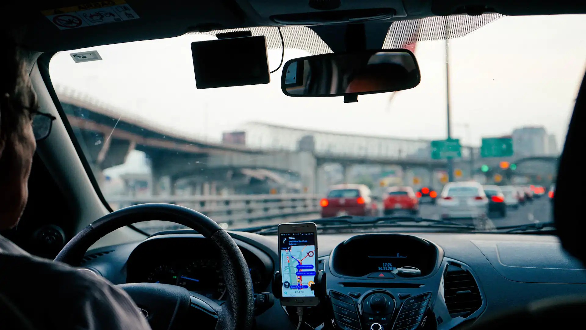 A DoorDash driver using a navigation app while driving a rented car for deliveries, highlighting the flexibility and convenience of car rentals for gig economy jobs.